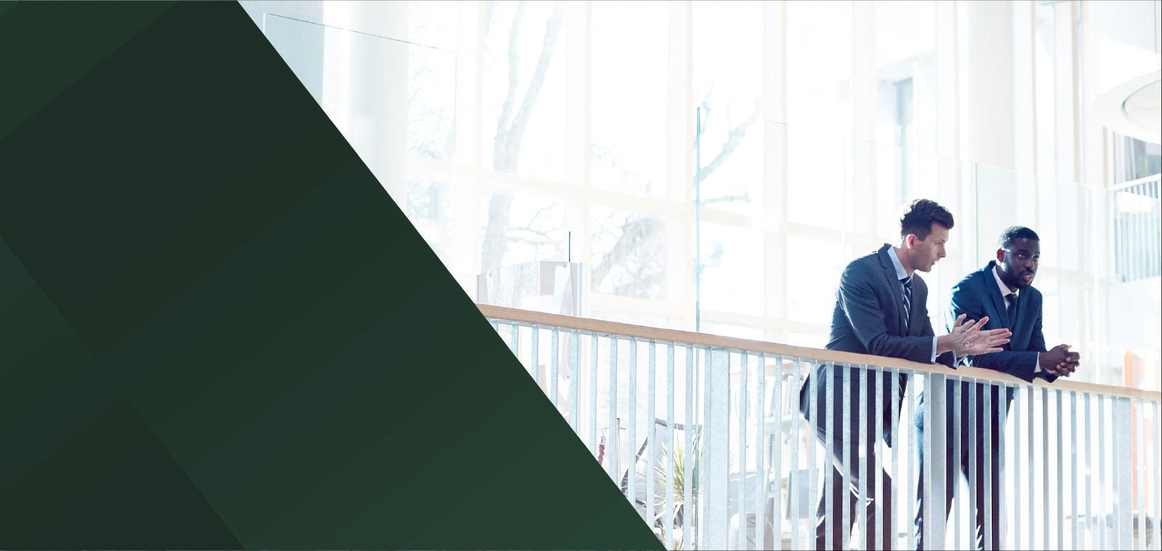 Two businessmen chatting at a balcony railing
