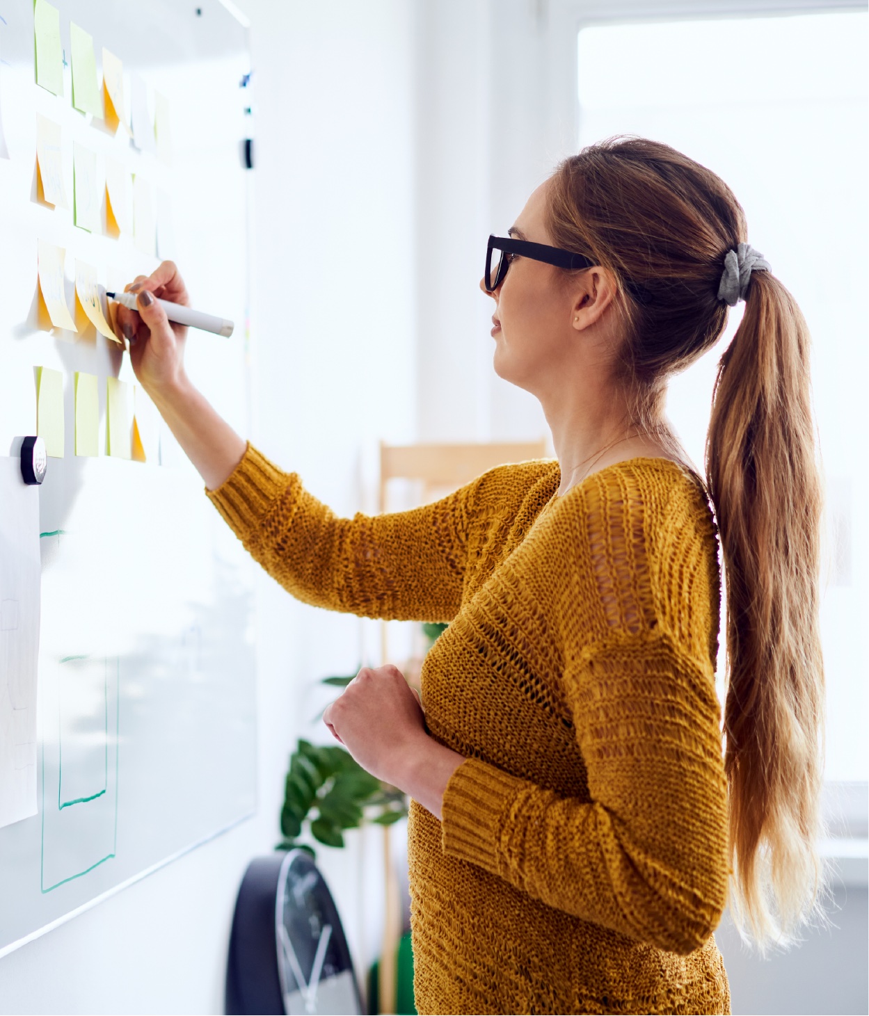 Woman writing on a whiteboard during a brainstorming session